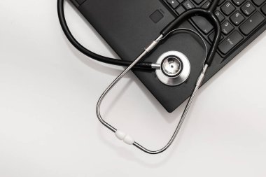 Metin için kopyalama alanı olan stetoskop ve bilgisayar. Beyaz arkaplan. Yakın plan..