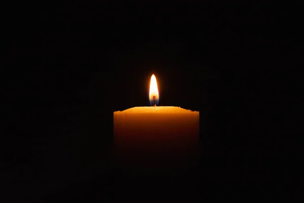 在黑色的背景里 一根光的蜡烛在明亮地燃烧着 黑暗中的烛焰 复制空间 — 图库照片