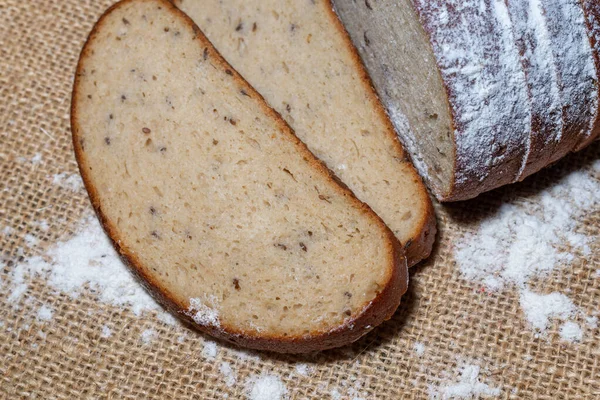 小麦粉パンの切り身と2枚のスライスがリネンベージュのキャンバスにカットされています — ストック写真