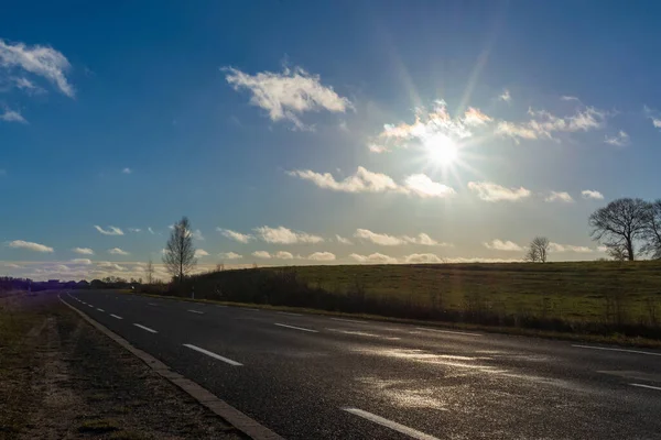 空のアスファルトの道路や太陽が天に昇るか 日没に行く古いアスファルトの道路 — ストック写真