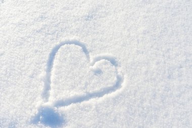 Bir el taze karda kalp şeklinde çizilmiş. Üst görünüm, yakın plan, boşluğu kopyala.