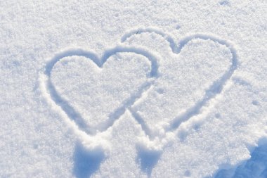 Çift taze karda kalp şeklinde çizilmiş..