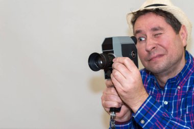 Kameralı adam, retro kamerayla film yapıyor. Ekose gömlekli adam, içeride Super 8 kamerayla çekim yapıyor. Yakın plan, seçici odak, kopyalama alanı..