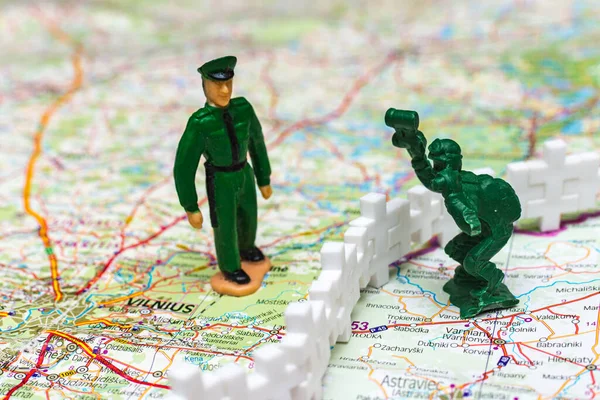 War and military concept. Two of miniature soldiers toy with tank on lithuanian belarus map