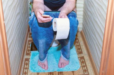 Tuvalette otururken akıllı telefon kullanan ve cep telefonuyla mesajlaşan bir adam. Sağlıklı bir kavram..