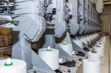 Beyaz tekstil iplik bükme makinesi. Tekstil fabrikasındaki makine ve ekipman..