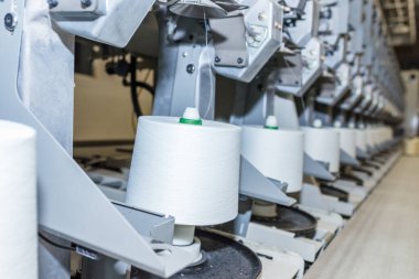 Beyaz tekstil iplik bükme makinesi. Tekstil fabrikasındaki makine ve ekipman..