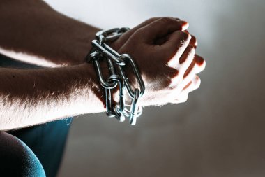 Zincirli zincire vurulmuş beyaz bir adam, hapis konsepti, suçlulara verilen ceza, insan ticareti, erkek ve kadınlara karşı şiddet..