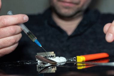 Şırınga eroin alıyor. Bağımlı karanlık oda. Uyuşturucu bağımlısı bir sonraki doz için hazırlanıyor..
