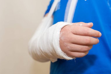 Çocuk, çocuk, eli alçılı çocuk beyaz arka planda. Yakın plan..