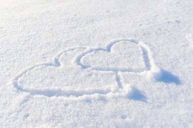 Çift taze karda kalp şeklinde çizilmiş..