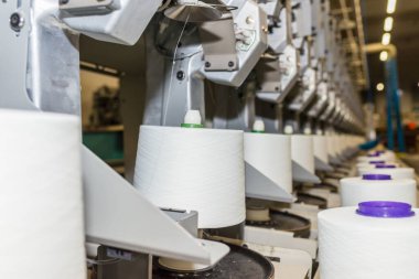 Beyaz tekstil iplik bükme makinesi. Tekstil fabrikasındaki makine ve ekipman..