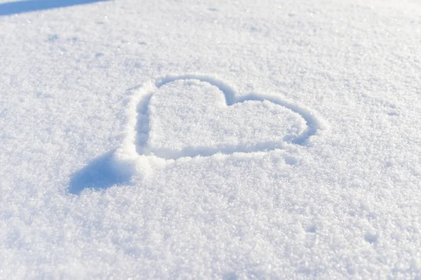 Bir el taze karda kalp şeklinde çizilmiş. Üst görünüm, yakın plan, boşluğu kopyala.