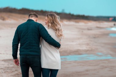 Genç çift bahar kumsalında birlikte vakit geçiriyorlar. Geçmişi bulanık, yakın plan..