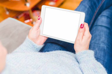 Evdeki kadın boş ekran ile tablet bilgisayarında rahatlıyor ve okuyor. Kapalı odaklan..