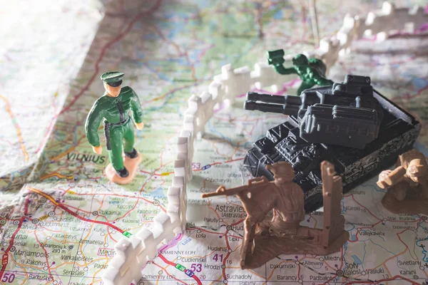 War and military concept. Group of miniature soldiers toy with tank on lithuanian belarus map