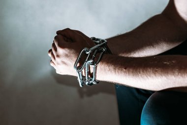Zincirli zincire vurulmuş beyaz bir adam, hapis konsepti, suçlulara verilen ceza, insan ticareti, erkek ve kadınlara karşı şiddet..