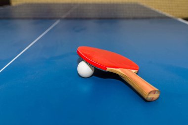 Dusty Paddle, tenis topu mavi masa tenisi masasına yakın. Mavi masa tenisi ya da ping pong. seçmeli odaklanma..