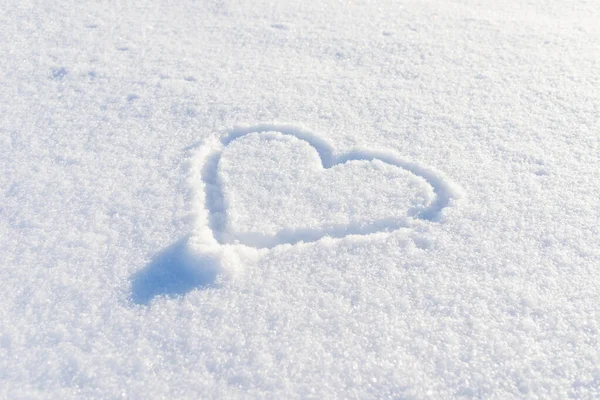 Bir el taze karda kalp şeklinde çizilmiş. Üst görünüm, yakın plan, boşluğu kopyala.