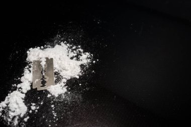 Razor Blade uyuşturucu tozunda yansıma siyah arka planda. Boşluğu kopyala.