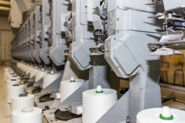 Beyaz tekstil iplik bükme makinesi. Tekstil fabrikasındaki makine ve ekipman..