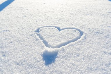 Bir el taze karda kalp şeklinde çizilmiş. Üst görünüm, yakın plan, boşluğu kopyala.