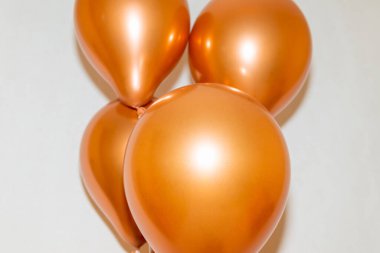 Beyaz bir stüdyonun arka planında altın balonlar..