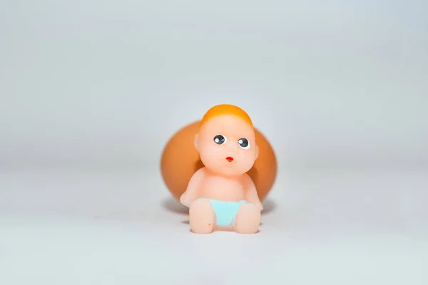 Brinquedo Bebê Recém Nascido Miniatura Ovo Sentado Fundo Cinza Branco — Fotografia de Stock