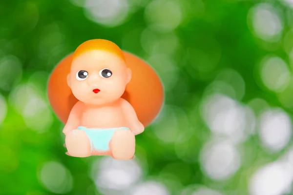 Miniature Newborn Baby Toy Egg Sitting Green Blurred Foliage Isolated — Fotografia de Stock