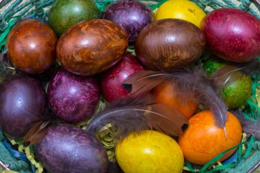 Yukardan bir yığın renkli paskalya yumurtası. Yukardan bakılır.Yumurtaların üzerinde tavuk tüyü var..