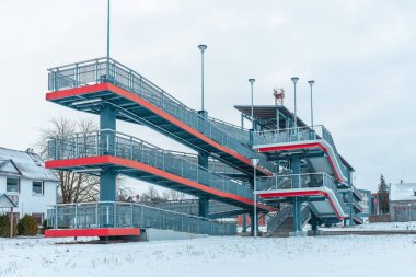 Modern yaya metal köprüsü bulutlu kış gününde demiryolu üzerinde yükseltildi. Telsiai, Litvanya 02-01-2022.