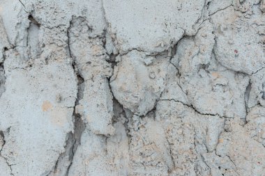 Çatlak beton duvarlı gri çimento yüzeyi arka planda. Kışın kırılan gri taş duvar. Yakın plan..