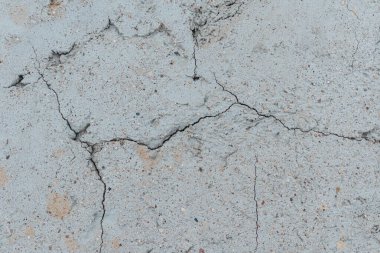 Çatlak beton duvarlı gri çimento yüzeyi arka planda. Kışın kırılan gri taş duvar. Yakın plan..