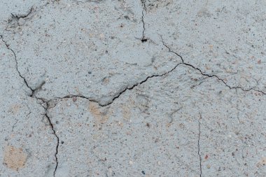 Çatlak beton duvarlı gri çimento yüzeyi arka planda. Kışın kırılan gri taş duvar. Yakın plan..