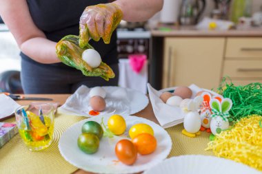 Paskalya yumurtası boyama. Kadın evdeki mutfakta paskalya yumurtası boyuyor..