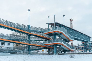 Modern yaya metal köprüsü bulutlu kış gününde demiryolu üzerinde yükseltildi. Telsiai, Litvanya 02-01-2022.