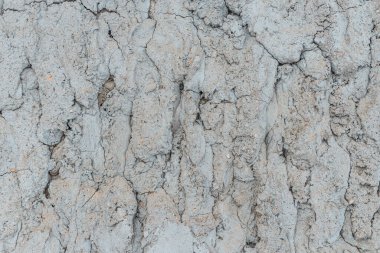 Çatlak beton duvarlı gri çimento yüzeyi arka planda. Kışın kırılan gri taş duvar. Yakın plan..