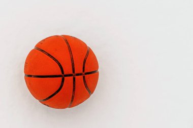 Karda duran turuncu basketbol topu fotokopi alanında yatıyor..