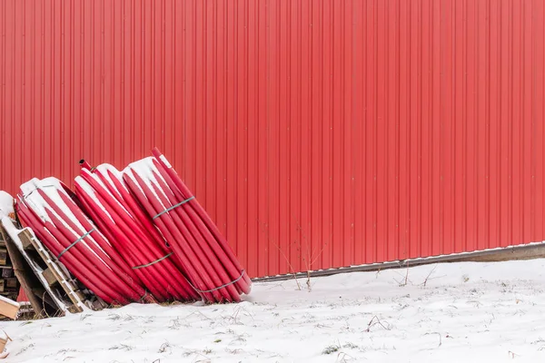 Tubos Plástico Vermelho Enrolados Armazenados Inverno Livre Perto Fundo Vermelho — Fotografia de Stock