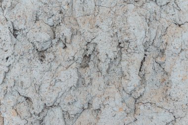 Çatlak beton duvarlı gri çimento yüzeyi arka planda. Kışın kırılan gri taş duvar. Yakın plan..