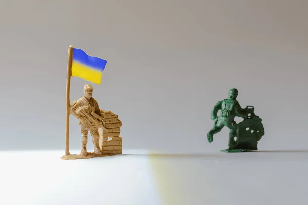 ミニチュアおもちゃウクライナの兵士は 距離で実行している兵士ウクライナのフラグを保持します — ストック写真