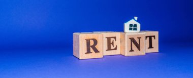 Tahta küplerin üzerinde kelime RENT ve minyatür oyuncak ev mor, veri peri arka planı. Banner.