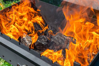 Açık havada yanan odun ateşi. Yazın güneşli bir günde Şaşlık fırını. Yakın çekim..