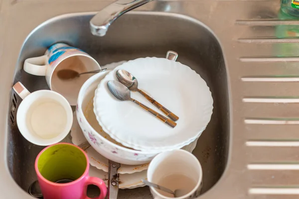 A lot of dirty dishes in the sink.Not washed dishes in the sink.Dishwashing liquid concept.