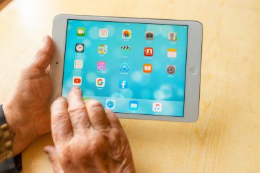 Üst düzey kadın internet üzerinden uygulama kullanarak alışveriş yapıyor, evinde oturuyor. Tablet bilgisayarlı yaşlı kadın. Seçici odaklanma. Yakın plan. Telsiai, Litvanya 05-08-2022.