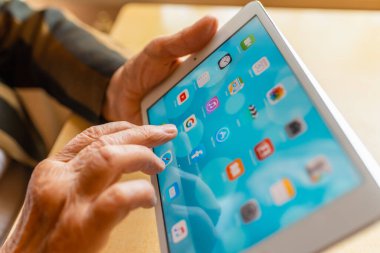 Üst düzey kadın internet üzerinden uygulama kullanarak alışveriş yapıyor, evinde oturuyor. Tablet bilgisayarlı yaşlı kadın. Seçici odaklanma. Yakın plan. Telsiai, Litvanya 05-08-2022.