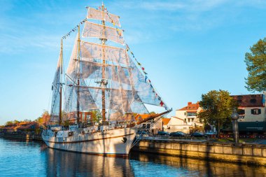 Günbatımında eski güzel gemi Meridian, mavi sakin gökyüzü, mavi su. Klaipeda şehrinin simgesi ve simgesi. Klaipeda, Litvanya - 05 Mayıs 2022.