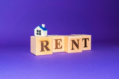Tahta küplerin üzerinde küçük oyuncak evleri olan kelime RENT, mor, veri peri arkaplan.