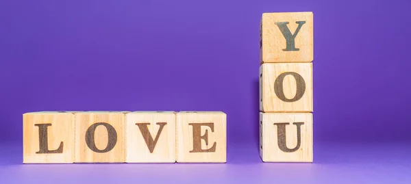 stock image i love you text on wooden blocks purple veri peri background.copy space.Banner.