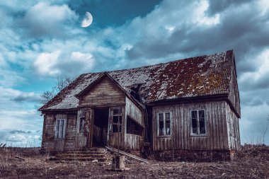 İhmal edilmiş eski ahşap ev, gece dramatik bulutlar. Terk Edilmiş Korku Evi. Ayla birlikte karanlık..